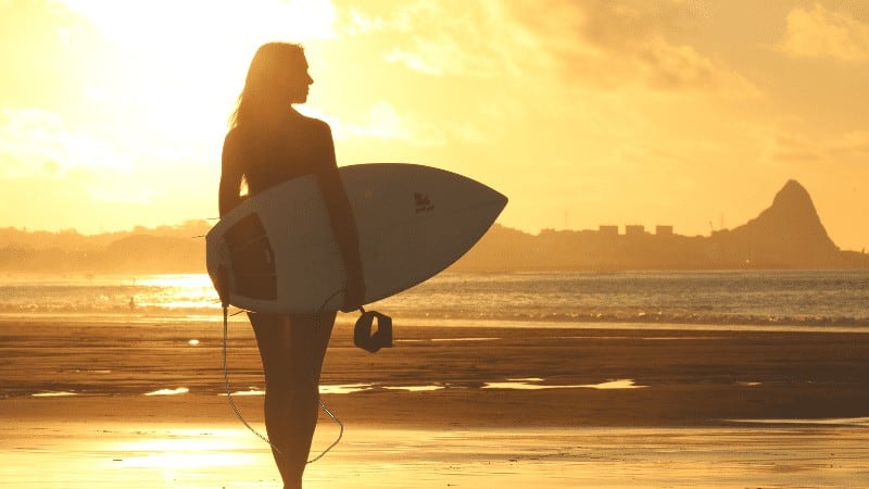 Standing Woman with Surfing Board and Sunset