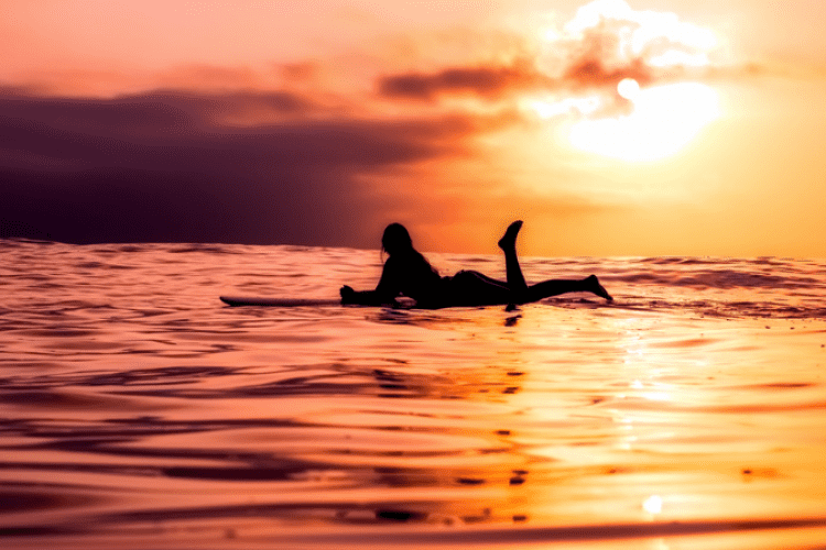 Girl Surfing in Maui at Sunset